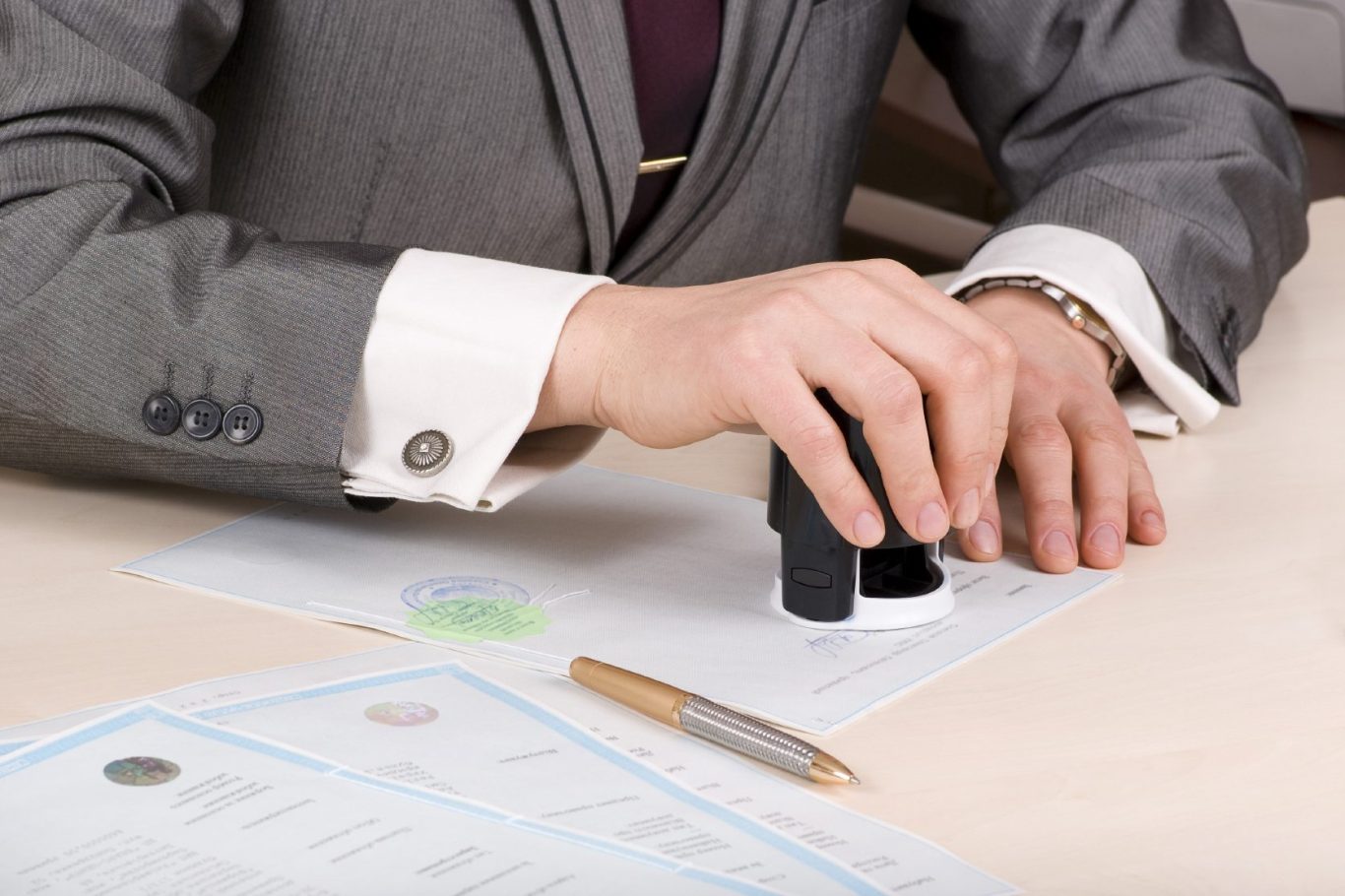 person in suit stamping an official looking document