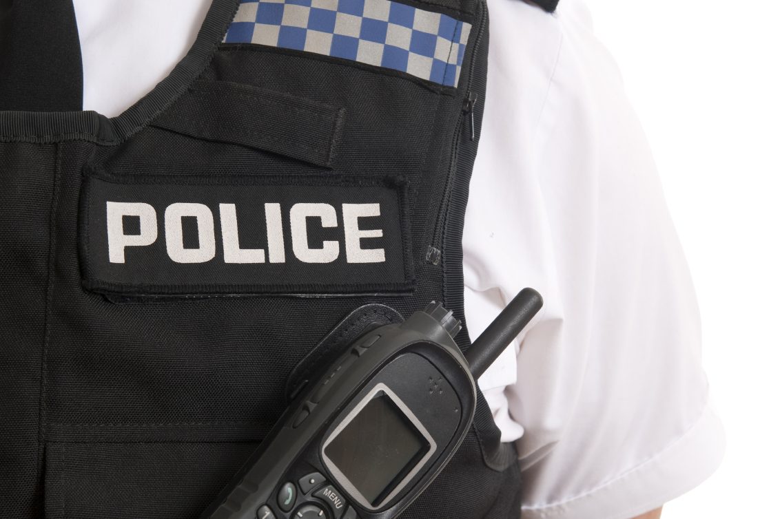 Left corner of a police vest with an older style police radio attached